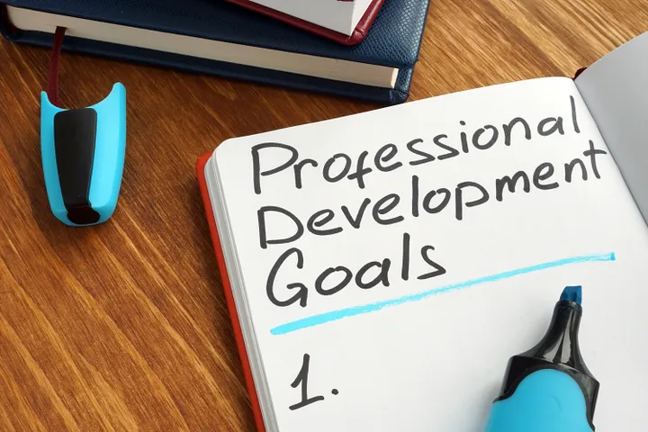 Photo of a journal with the words Professional development goals written on a left page of the journal.
